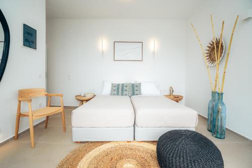 a bedroom with a bed and a table and a vase at Melianthos Villas in Vathi, Sifnos