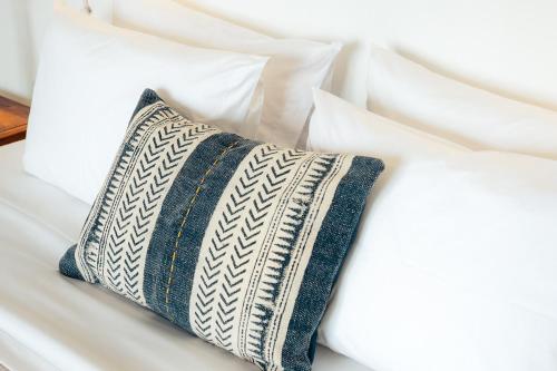 a pillow sitting on top of a white bed at Melianthos Villas in Vathi, Sifnos