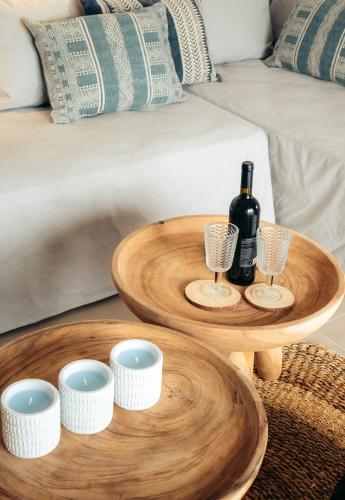 a table with a bottle of wine and glasses on it at Melianthos Villas in Vathi, Sifnos