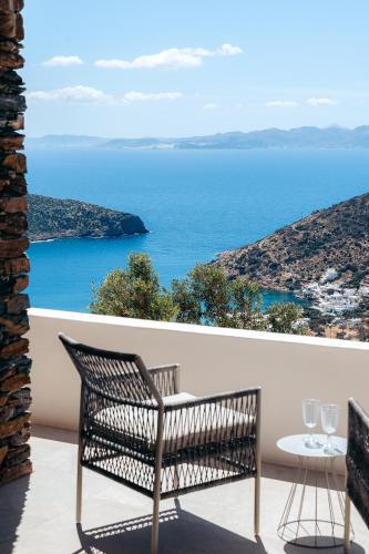 a bench on a balcony with a view of the ocean at Melianthos Villas in Vathi, Sifnos