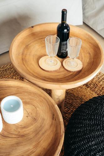 a wooden table with a bottle of wine and glasses at Melianthos Villas in Vathi, Sifnos