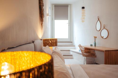 a bedroom with a bed and a table and a desk at Melianthos Villas in Vathi, Sifnos