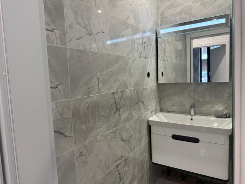 een badkamer met een wastafel en een spiegel bij Сарафово Лукс Тераса Първа Линия in Sarafovo