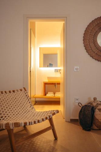 a room with a mirror and a bench and a chair at Melianthos Villas in Vathi, Sifnos