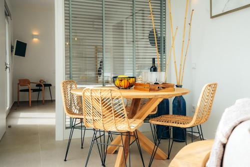 a dining room table with rattan chairs in a room at Melianthos Villas in Vathi, Sifnos