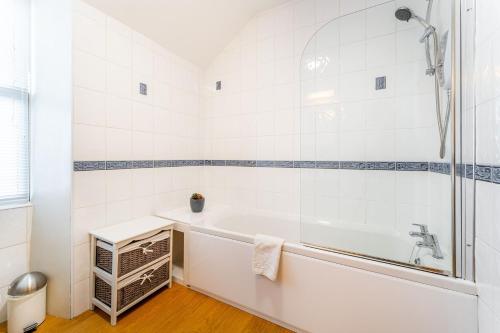 biała łazienka z wanną i prysznicem w obiekcie Daisy Cottage w mieście Windermere