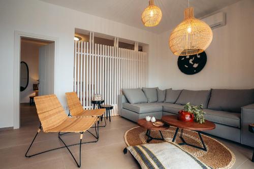 a living room with a couch and a table and chairs at Melianthos Villas in Vathi, Sifnos