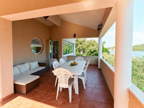 eine Terrasse mit einem Tisch, Stühlen und einem Sofa in der Unterkunft Apartments Eva in Savar