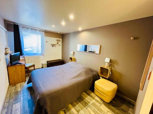 Schlafzimmer mit einem Bett, einem Schreibtisch und einem Fenster in der Unterkunft Hôtel Restaurant La Forge in Castellane