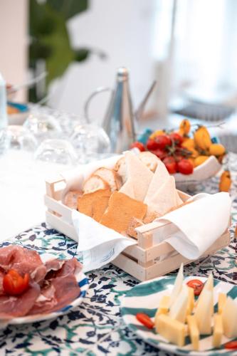 un tavolo con piatti di cibo e una scatola di formaggio di AMORE RENTALS - Villa Blu a Praiano