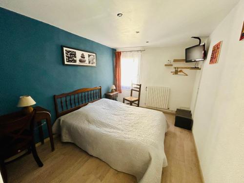 una camera con letto e parete blu di Hôtel Restaurant La Forge a Castellane