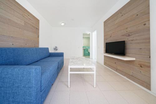 a living room with a blue couch and a tv at Smy Tahona Fuerteventura in Caleta De Fuste