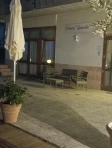 a living room with a couch and chairs and an umbrella at Camere Girasole in Lazise