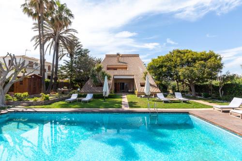 une piscine en face d'une maison avec des palmiers dans l'établissement Dolce Vita B&B - Only Adults, à Valence