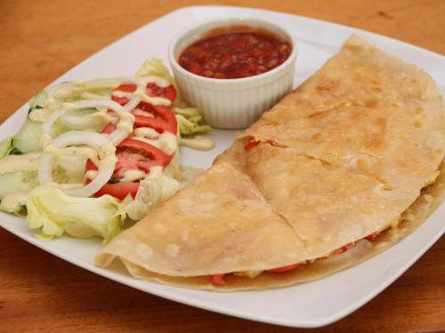 a plate of food with a sandwich and lettuce and salsa at Badladz Beach and Dive Resort in Puerto Galera