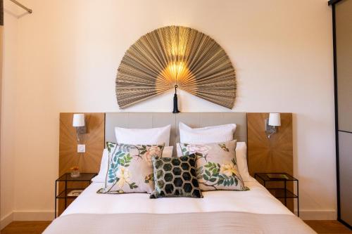 - une chambre avec un lit et un grand ventilateur au-dessus dans l'établissement Villas Presqu'île de la Lagune, à Saint-Cyprien