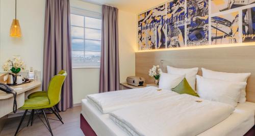 a hotel room with a large bed and a desk and a desk at PLAZA INN Bad Rappenau in Bad Rappenau