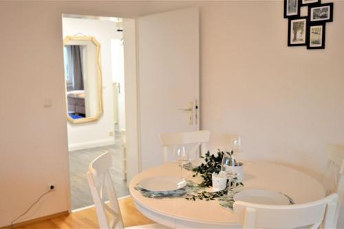 - une salle à manger blanche avec une table et des chaises blanches dans l'établissement Rüttenscheid/ Große Wohnung, à Essen