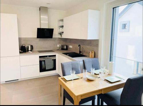 een keuken met een houten tafel met stoelen en een eetkamer bij Brand New Luxury Studio in Belair with balcony in Luxemburg