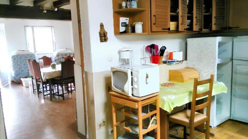 eine Küche mit einem Tisch und einer Mikrowelle in der Unterkunft Maison d'une chambre avec wifi a Saint Pere in Saint-Père