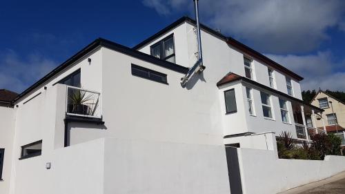 a white house with a white wall at Charnwood Guest House in Lyme Regis