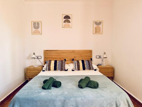 a bedroom with a bed with two green pillows on it at Villa In Playa Den Bossa & Ibiza Town 7min, Bbq in Sant Josep de sa Talaia