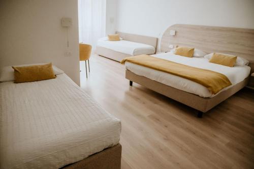 una camera d'albergo con due letti e un divano di Hotel Venezia a Trento