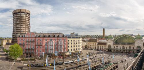 Blick auf eine Stadt mit Bahnhof und Gebäuden in der Unterkunft Hotel Schweizerhof Basel in Basel