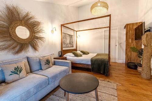 a living room with a couch and a bed at Hôtel Quai des Pontis in Cognac