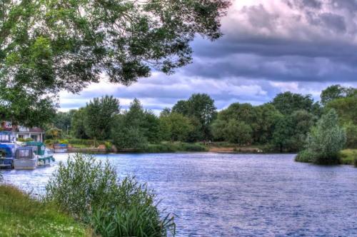 a view of a river with a boat on it at Pass the Keys Bright modern flat wparking in Addlestone