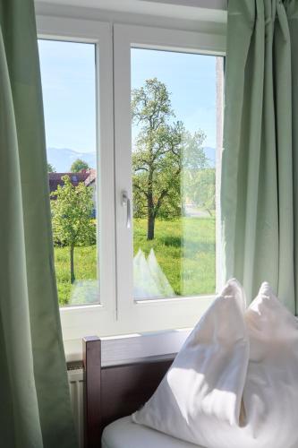 a bedroom window with a view of a tree at Naturidyll am See in Fußach