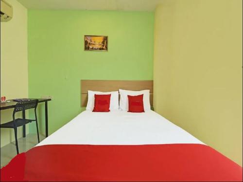 ein Schlafzimmer mit einem Bett mit zwei roten Kissen in der Unterkunft South City Hotel @ Bandar Mahkota Cheras in Kuala Lumpur