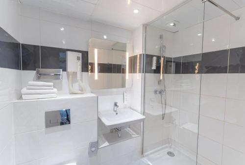 y baño blanco con lavabo y ducha. en Hotel Inn Design Paris Place d’Italie (ex Timhotel), en París