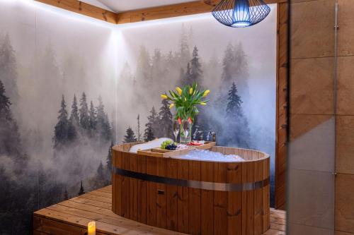 a hot tub in a room with a painting of trees at Hotel Willa Pod Skocznią in Zakopane