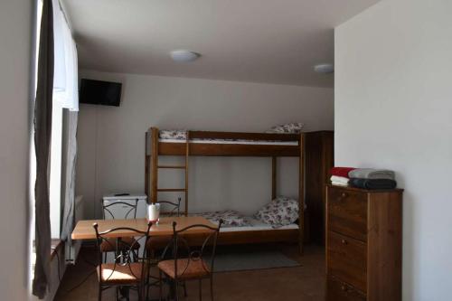 プルシーブラムにあるHornický penzionのデスク、ベッド、テーブル、椅子が備わる客室です。