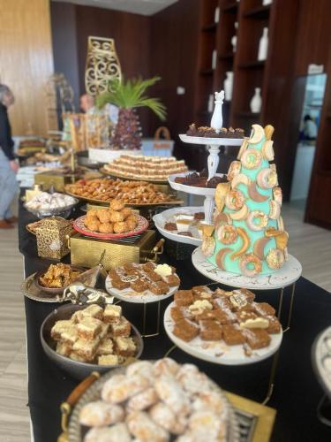 a table filled with different types of pastries and desserts at Waves Aqua Resort in Kenitra
