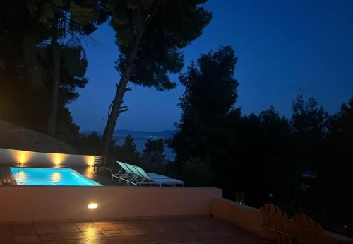 una piscina in un cortile posteriore di notte di Askalosia villa a Agios Georgios