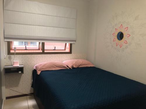 a bedroom with a blue bed and a window at KitFrida sudoeste in Brasília