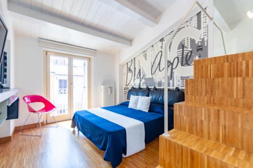 ein Schlafzimmer mit einem blauen Bett und einem roten Stuhl in der Unterkunft Appartamento Duplex Cairoli - MyHo Casa in Porto San Giorgio