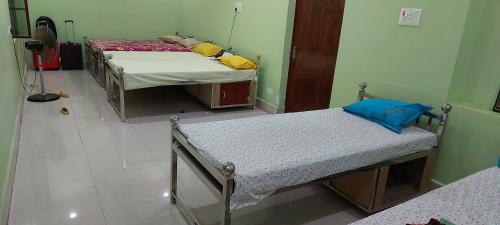 a room with two beds in a room at Anand Bhavan in Deoghar
