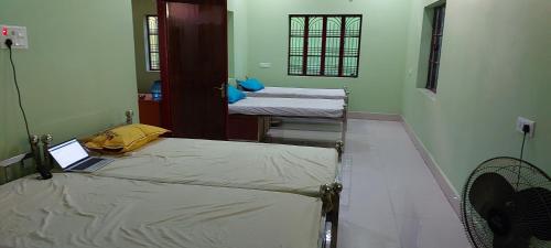 Anand Bhavan في دوغار: غرفة بها سريرين وجهاز كمبيوتر محمول