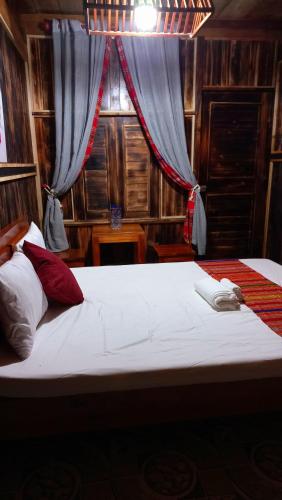 a bedroom with a large bed with a window at Puluong Bao Gia Homestay in Làng Bang