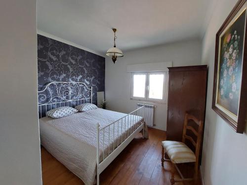 Un dormitorio con una cama con una pared de acento azul en Casa Azul Vales, en Penalva do Castelo
