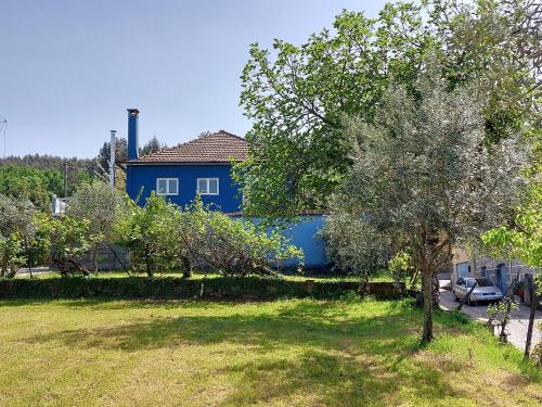 a blue house with a tree in a yard at Casa Azul Vales in Penalva do Castelo