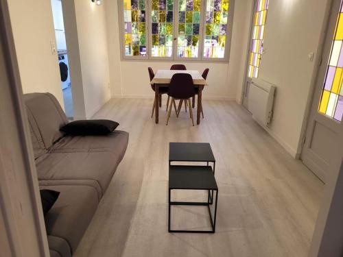 un salon avec un canapé et une table avec des chaises dans l'établissement la celiva, à Quend