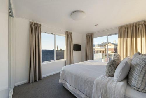 1 dormitorio con cama y ventana grande en Battery Point Beauty, en Hobart