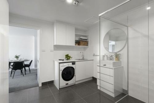 荷伯特的住宿－Battery Point Beauty，白色的厨房配有洗衣机和桌子