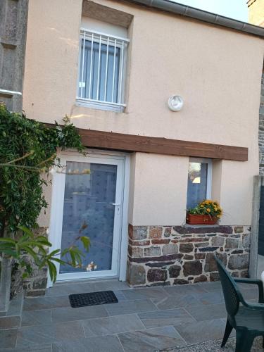 une maison avec une porte, une fenêtre et un mur en pierre dans l'établissement Gîte coeur de Brocéliande, à Néant-sur-Yvel