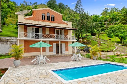 a villa with a swimming pool and a house at Paradisiacal getaway -Serra Negra in Serra Negra