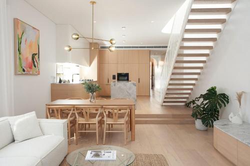 a living room with a table and a staircase at Bondi Casa del Sol in Sydney